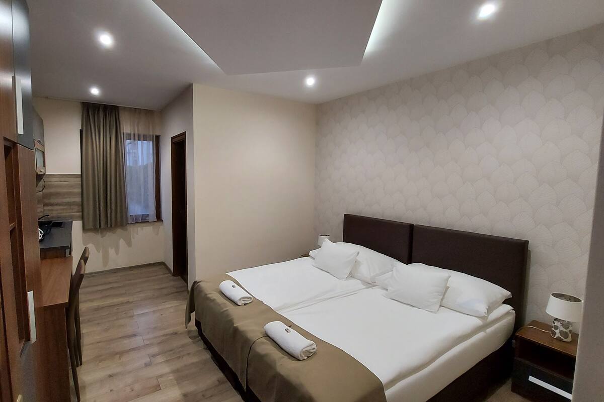 Una habitación de hotel con una cama, un escritorio y una silla.