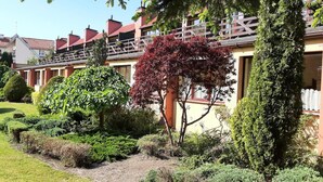 A row of residential buildings with a well-maintained garden in front.