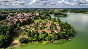 An aerial view of a lakeside village with traditional architecture, a church, and a river.