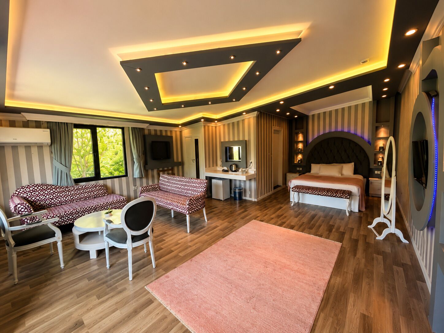 Una habitación de hotel moderna con sofá, escritorio y cama.