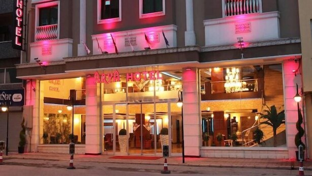 Een hotel met meerdere verdiepingen, balkons, grote ramen en een opvallende ingang.