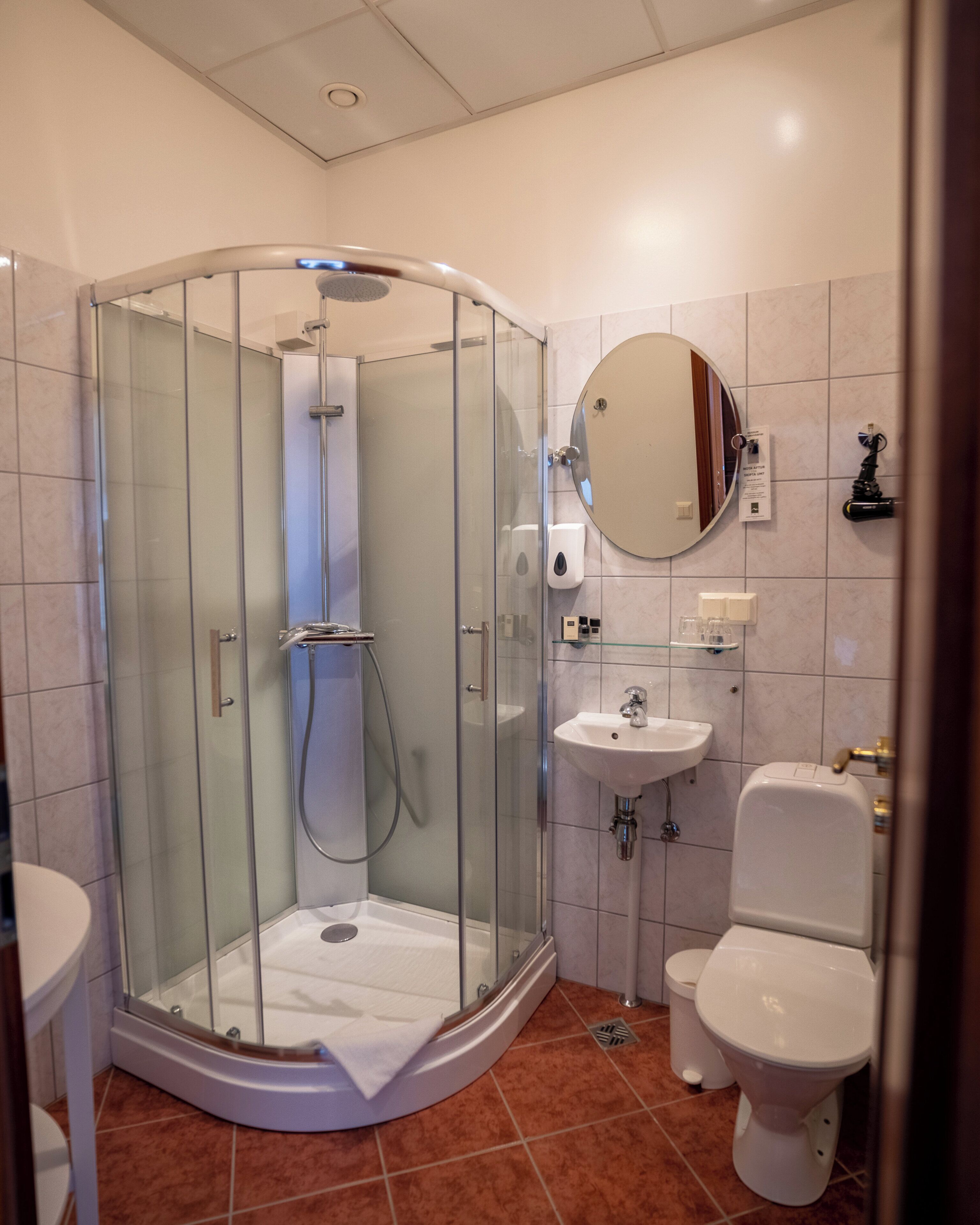 A modern bathroom with a glass-enclosed shower, a sink, and a toilet.