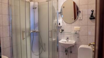 A modern bathroom with a glass-enclosed shower, a sink, and a toilet.