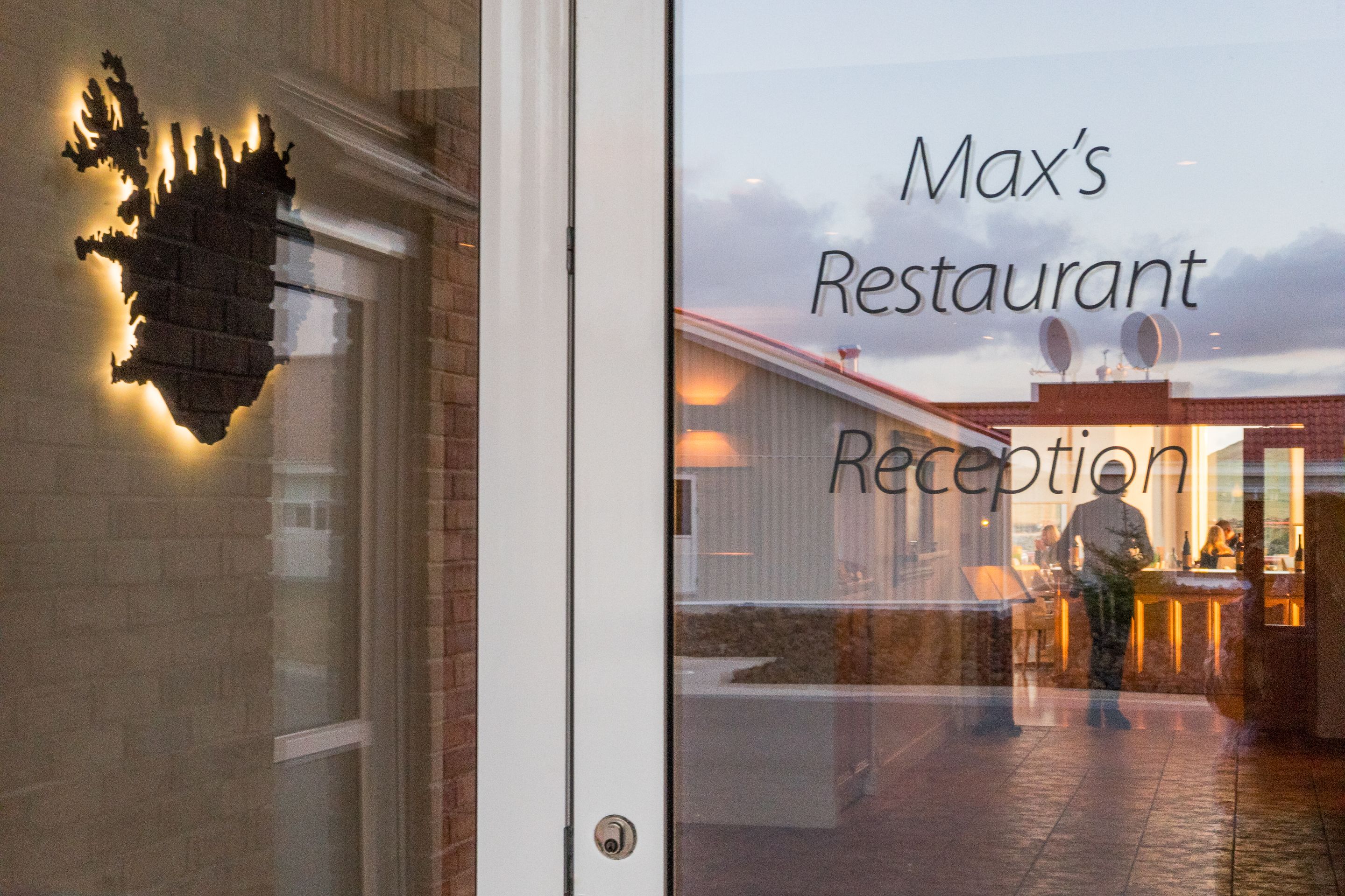 A restaurant entrance with a reception area visible through the glass.