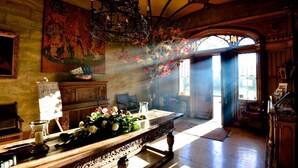 A room with a large wooden table, a chandelier, and a stained glass window. - Belleek Castle (Ballina)