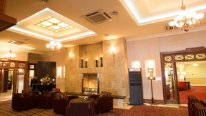 A hotel lobby with a fireplace, seating area, and a reception desk. - Hamlet Court Hotel (Johnstown Bridge)