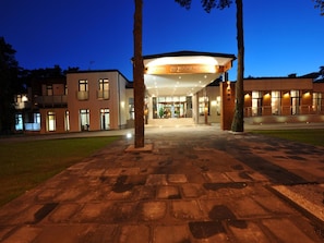 A modern hotel entrance with a covered walkway, a clear sky, and a well-lit facade. - Hotel Grzegorzewski (Tuszyn)