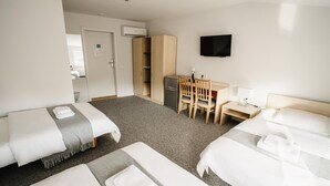 A hotel room with two beds, a desk, a chair, a television, and a wardrobe. - Hotel Tomas (Siauliai)