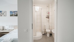 A modern bathroom with a shower, toilet, and sink. - Hotel Tomas (Siauliai)