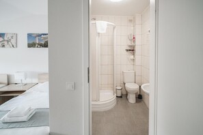 A modern bathroom with a shower, toilet, and sink.