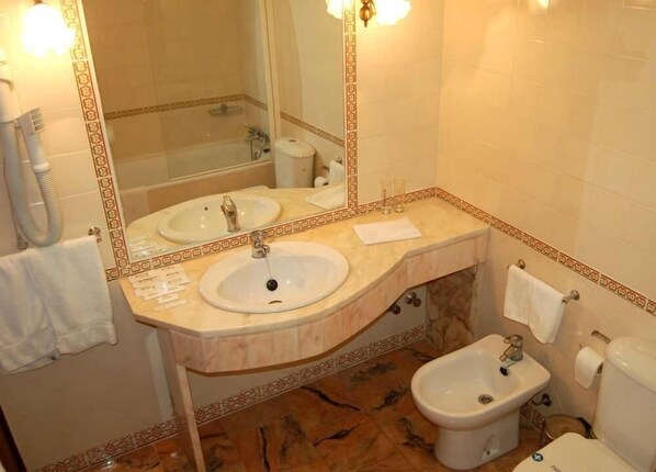A bathroom with two sinks, a bidet, and a toilet. - Jardim (Elvas)