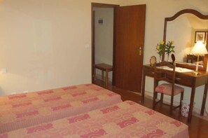 A bedroom with two beds, a wooden desk, a chair, and a mirror. - Jardim (Elvas)
