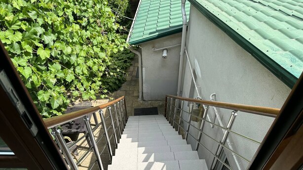 A staircase with metal railings and a green roof visible in the background. - Hotel Lidia (Chisinau)