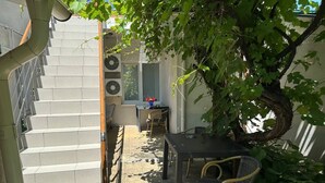 A staircase leading to a covered outdoor area with a table and chairs, surrounded by greenery. - Hotel Lidia (Chisinau)