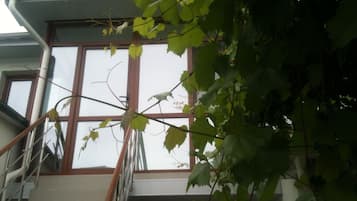 Una escalera que lleva a un ventanal del segundo piso con vista a un edificio.
