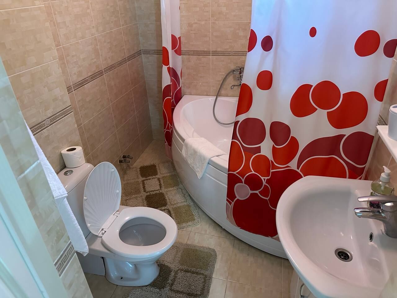 Un baño con inodoro, lavabo y ducha.