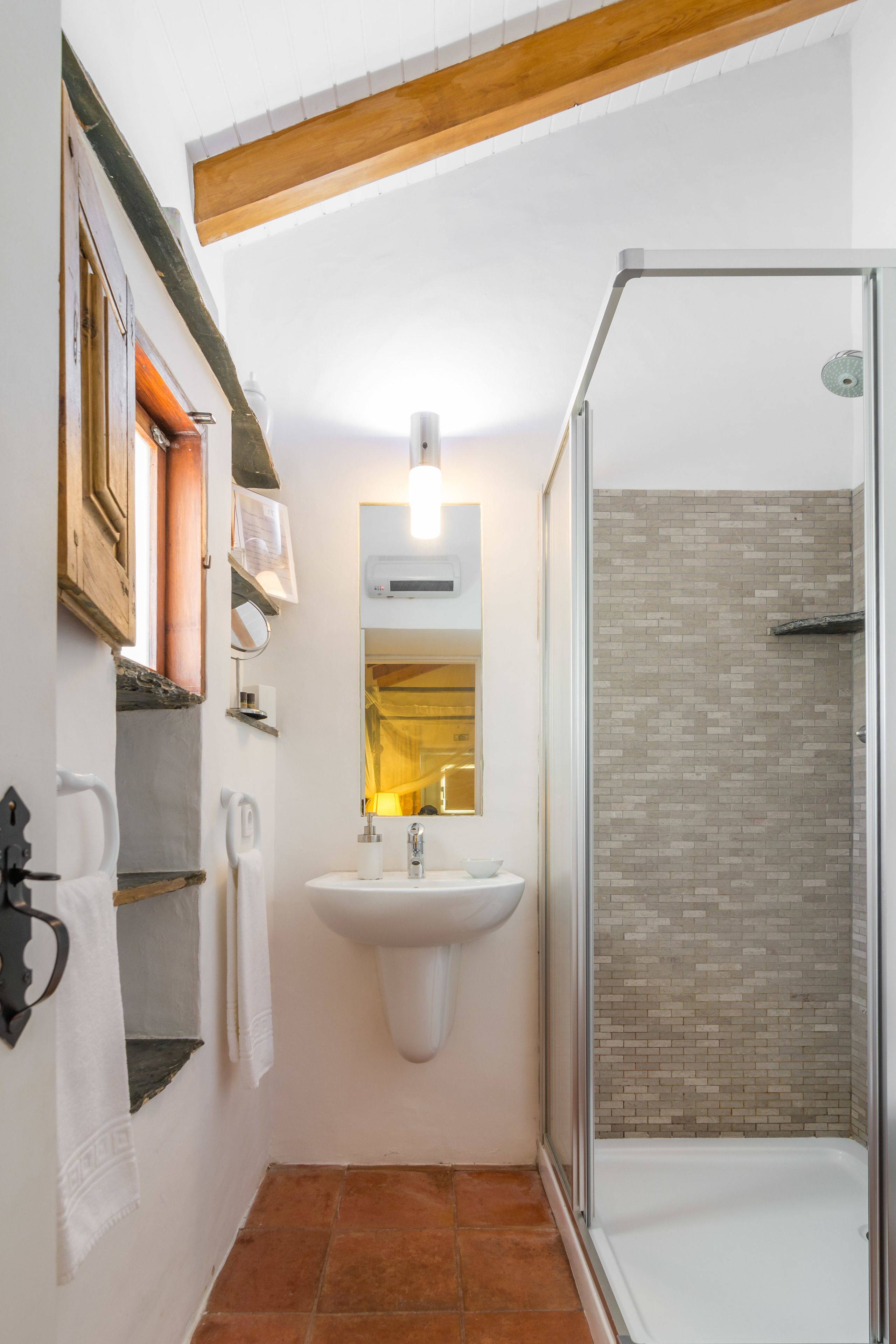 Ein Badezimmer mit Dusche, Waschbecken und Spiegel.