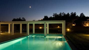 Una piscina con una vista despejada del cielo y una luna creciente.