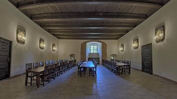 A long dining hall with high ceilings and arched windows.