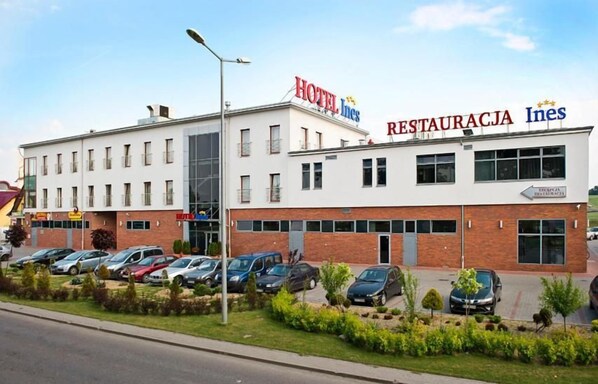 A hotel with a restaurant and a parking lot.