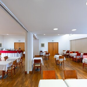 Zona de dinar amb taules i caires, dispositiu d'estil bufet i sòl de fusta.