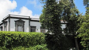 A building with a classical architectural style, featuring a symmetrical facade with columns and a central entrance. - Casa Do Jardim (Ponta Delgada)