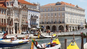 A riverside scene with boats, a bridge, and historic buildings.