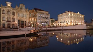 A waterfront hotel with a reflection in the water, featuring classical architecture and a canal. - TURIM Aveiro Palace Hotel (Aveiro)
