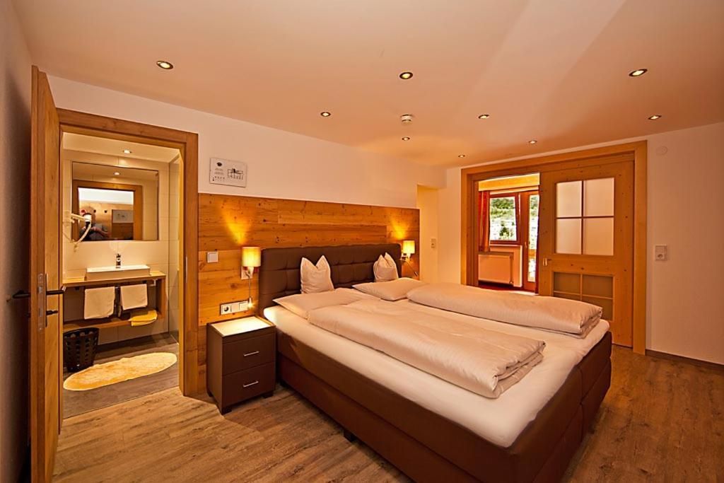 Una camera da letto con un letto grande, comodini, uno specchio e una testiera in legno.