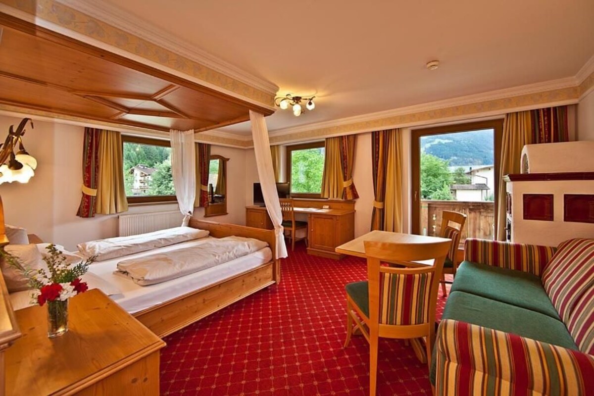 Une chambre d’hôtel équipée d’un lit, d’un bureau, d’une chaise, d’un canapé et offrant une vue sur l’extérieur.