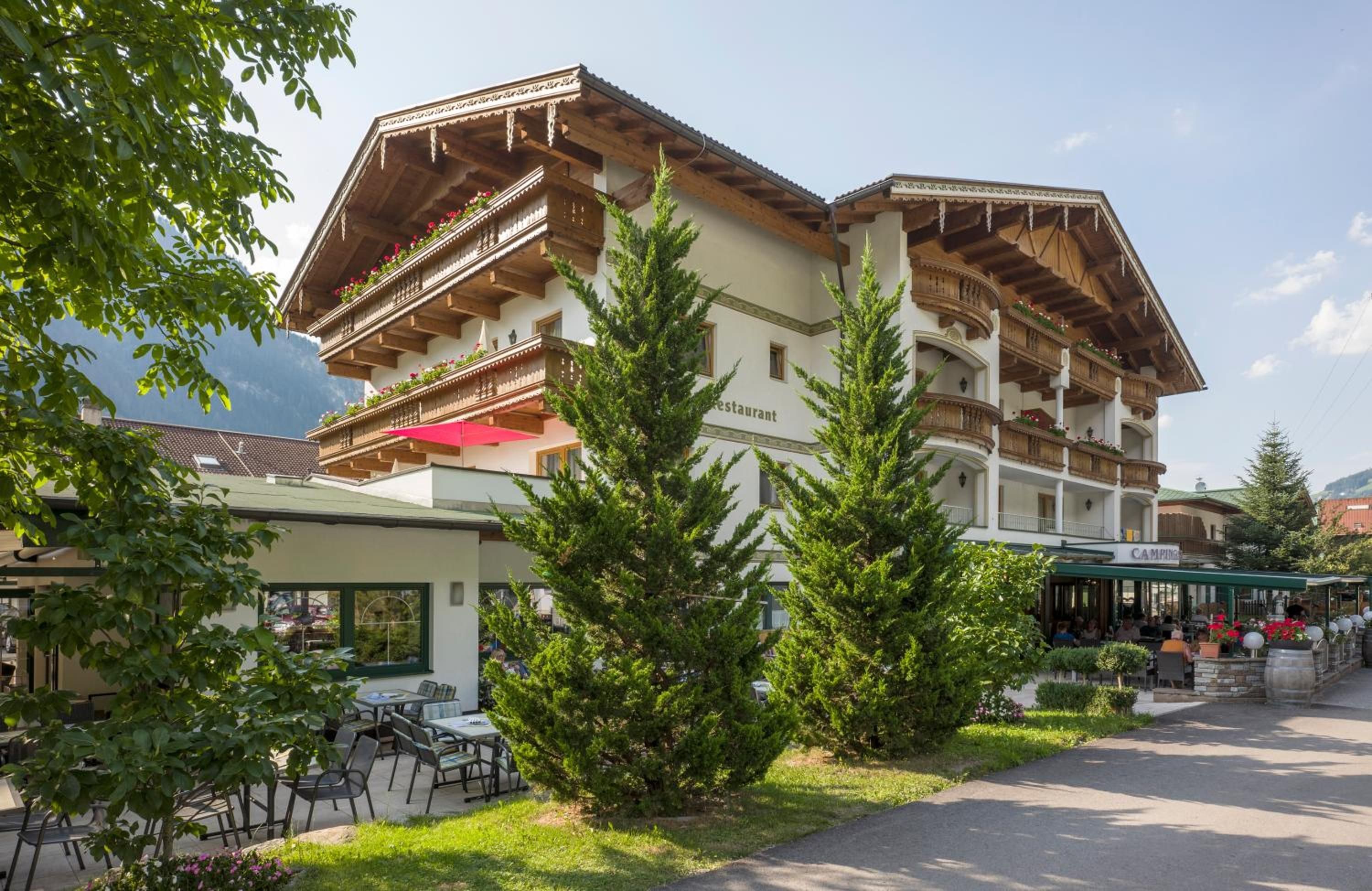 A traditional chalet-style building with multiple balconies, a restaurant, and outdoor seating.