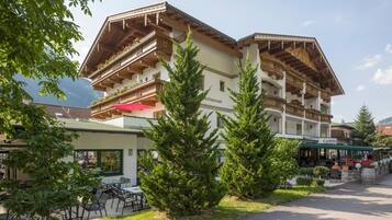 A traditional chalet-style building with multiple balconies, a restaurant, and outdoor seating.