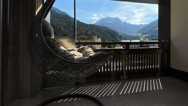 A room with a large window overlooking a mountainous landscape. - Glück auf (Mayrhofen)