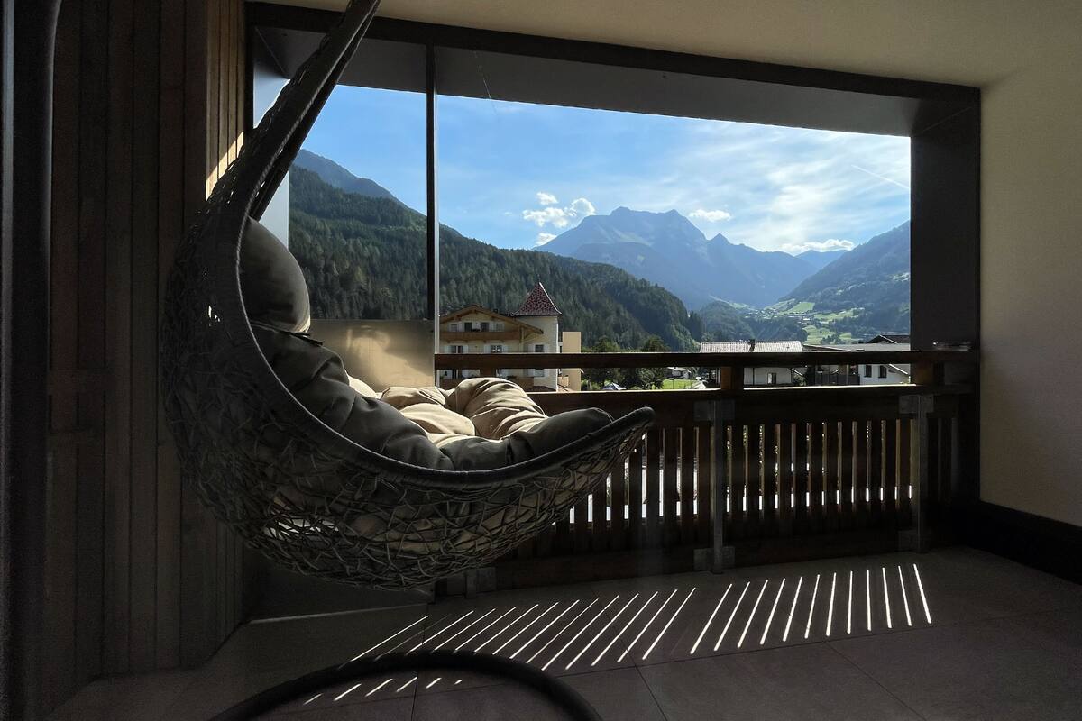 A room with a large window overlooking a mountainous landscape.