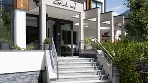 A modern building with a staircase leading to a covered entrance. - Glück auf (Mayrhofen)
