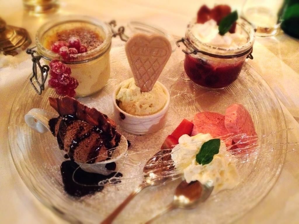 A dessert platter with various sweet treats including ice cream, chocolate, and fruit.