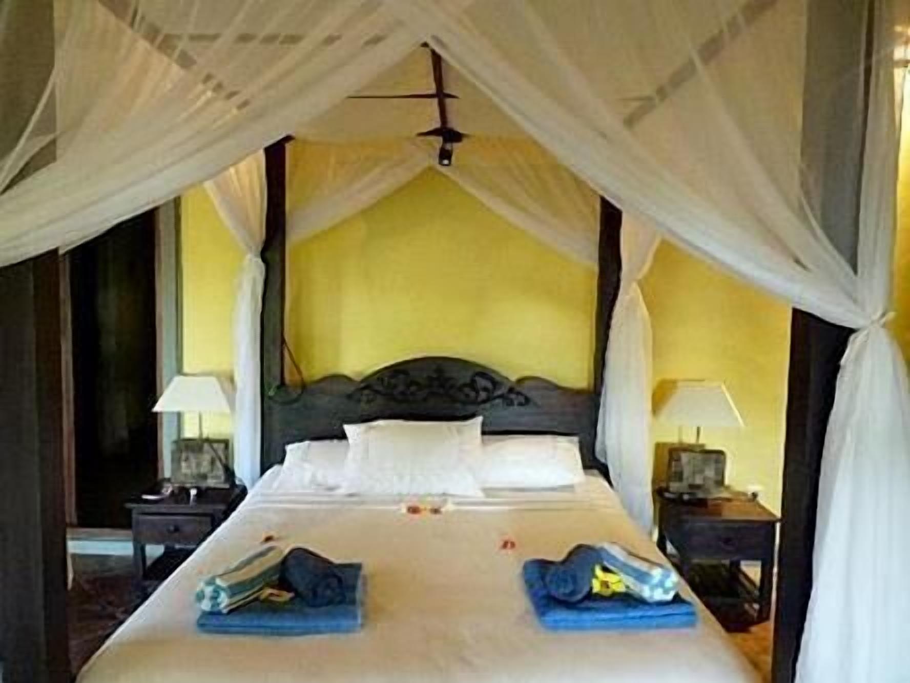 A bed with a canopy, two bedside tables, and a nightstand.