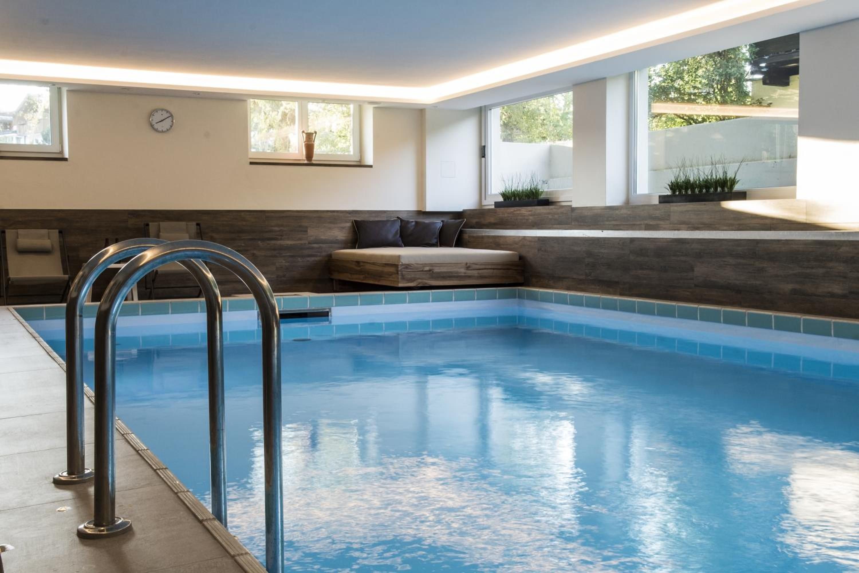 Una piscina con un banco integrado y una escalera.