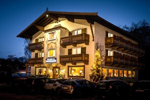 A multi-story hotel with a traditional architectural style, featuring balconies and a sign indicating it is a hotel. - Hotel Garni Entstrasser (Kitzbühel)