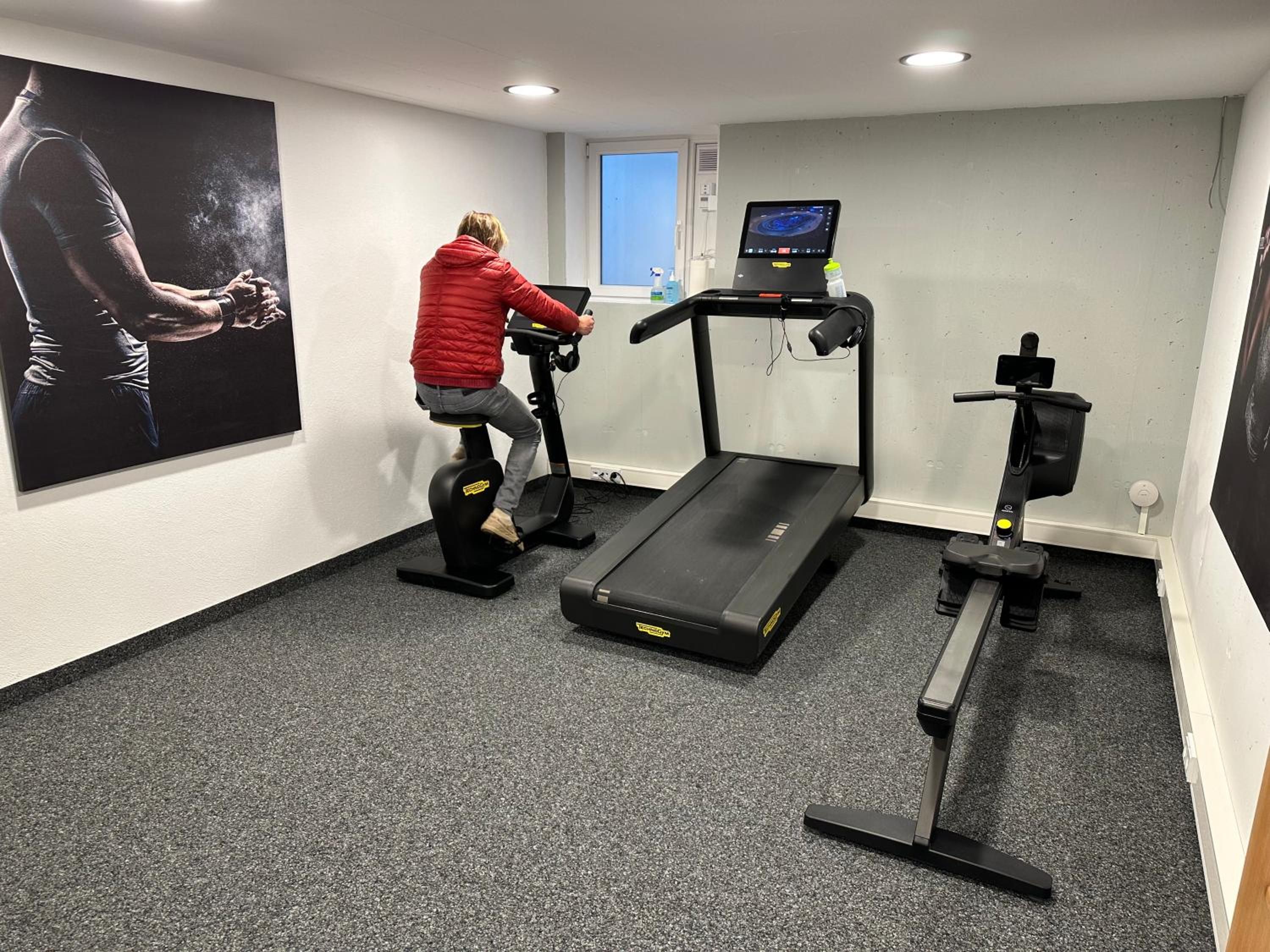 Gimnasio en casa con cinta de correr, elíptica y bicicleta estática.