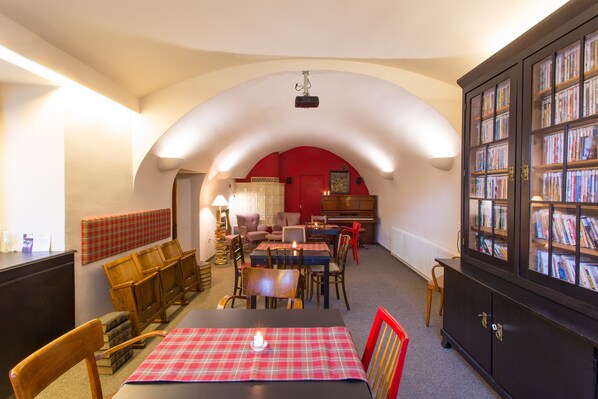 Une salle de lecture chaleureuse, dotée d’une cheminée, de bibliothèques et de sièges confortables.