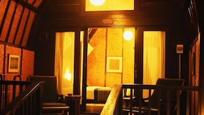 Una stanza accogliente con un letto, una panca di legno e una scala.