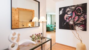 Ein modernes Interieur mit einem Glastischchen, einem großen Spiegel und einem zeitgenössischen Gemälde.
