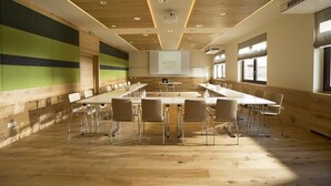 A conference room with long tables and chairs, a wooden ceiling, and a banner reading "HOTEL FAST." - Mein Hotel Fast (Wenigzell)
