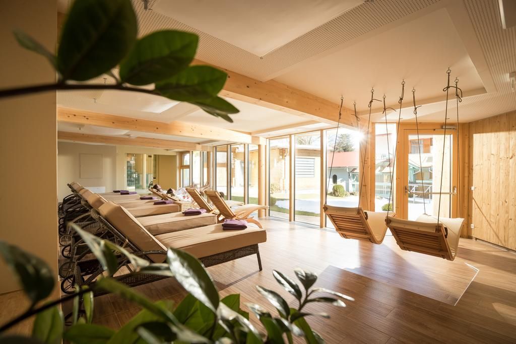 A spa room with wooden floors, large windows, and multiple lounge chairs.