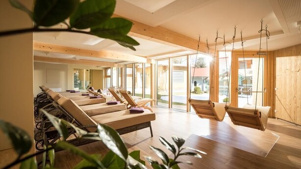 A spa room with wooden floors, large windows, and multiple lounge chairs. - Mein Hotel Fast (Wenigzell)