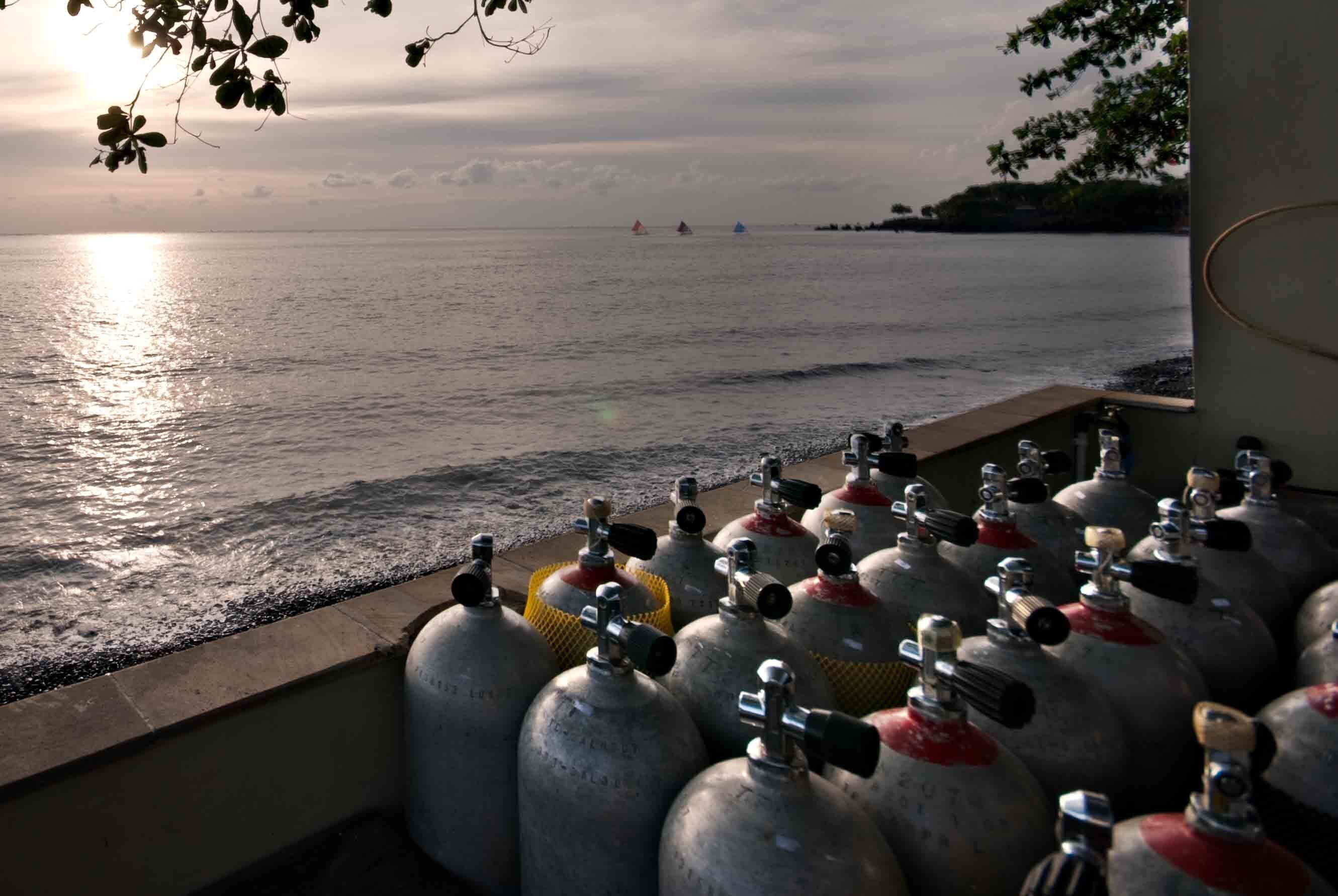 Blick auf das Meer mit mehreren Gasflaschen, die auf einer Anhöhe aufgereiht sind.