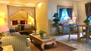 Une pièce confortable comprenant un lit, un canapé, une table basse en bois et un coin repas avec une table et des chaises.