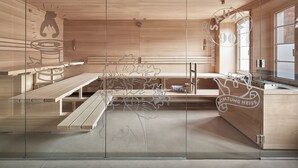 Una moderna sauna con panche in legno, una parete in vetro con la silhouette di un orso e il logo della sauna.