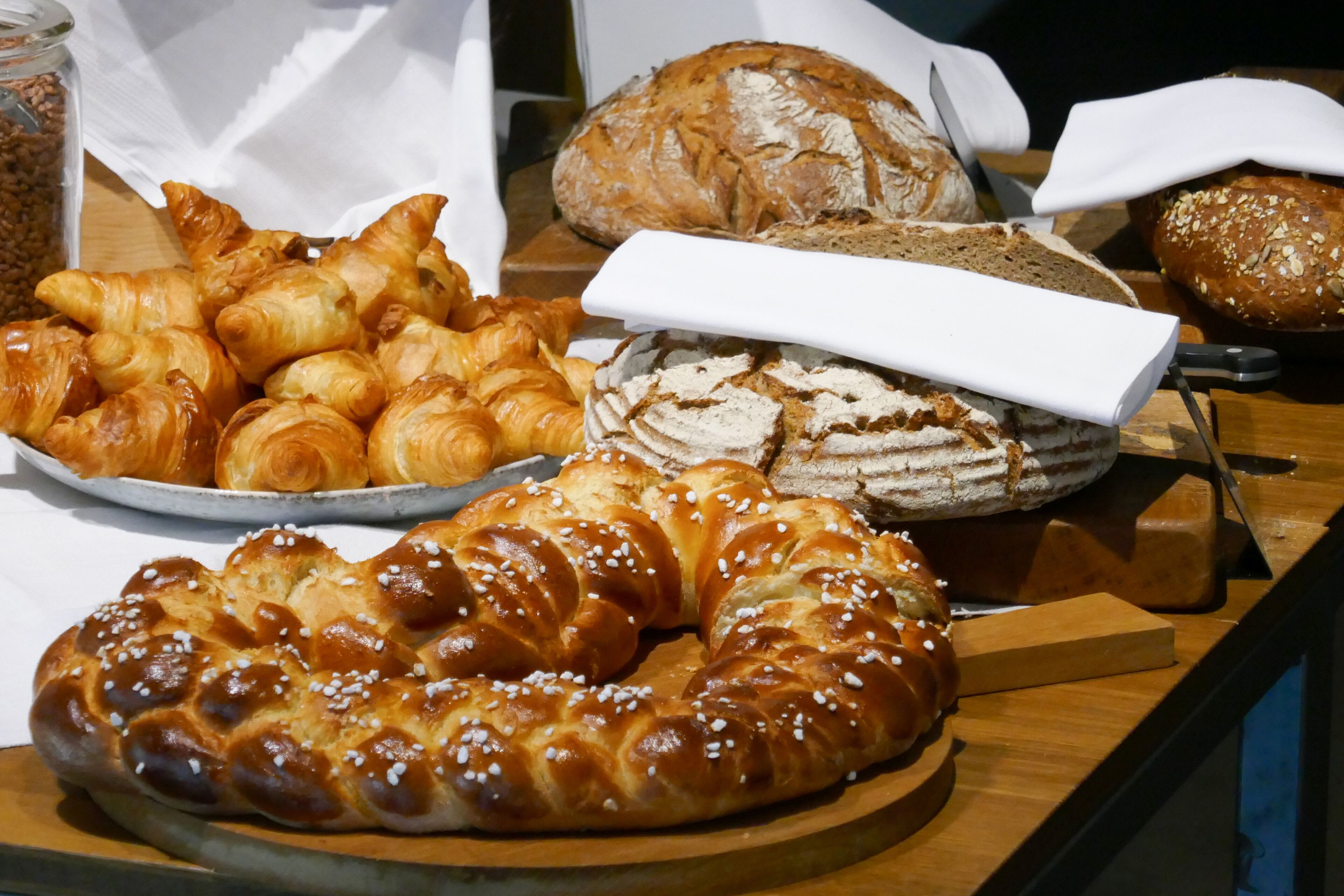 Variedad de panes y pasteles sobre una mesa de madera.